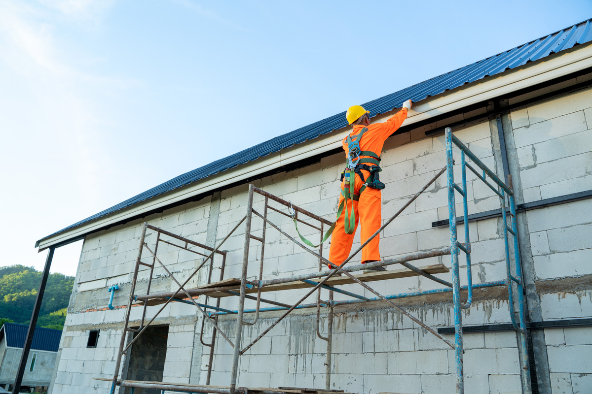 Working at height equipment,Construction worker wearing safety harness belt during working on roof structure of building.